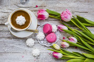 French macaroons delicious cookies with coffee and pink tulips for Valentine's Day.