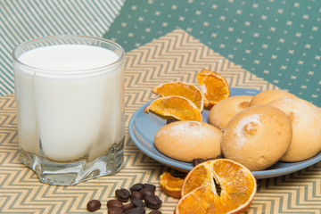 Glass of milk and plate with cookies