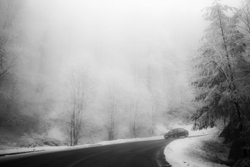Road in the fog. Mysterious Way. Snowy mountain road. Risk of ic