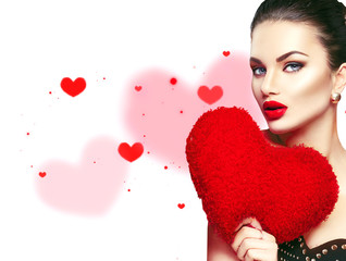 Valentine's Day. Sexy model girl portrait. Gorgeous young brunette woman with heart shaped purple pillow isolated on white