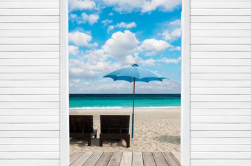 Wood bed and umbrella at sand beach of Thailand,  with blue sky