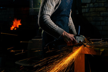 Sparks flying over the working table during metal grinding.