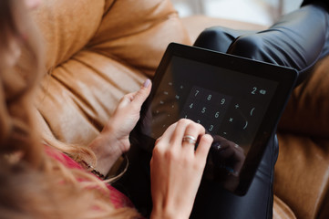 Close-up of the hands of a young woman working with the tablet a