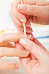 Preparing nails before manicure, pushing back cuticles