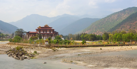 Fototapeta na wymiar Bhutan panorama landscape. Punakha Dzong, famous buddhist monastery and fortress of traditional style in the valley between two rivers in Bhutan, Himalaya mountains, Asia.