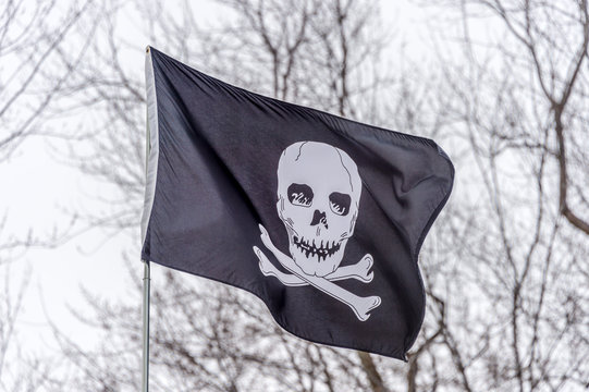 Black and white pirate flag waving in the sky