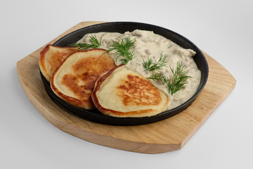 Flapjack with mushroom sauce on wooden plate