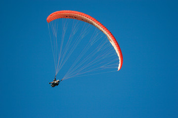 Paraglider flying across blue sky on a summer's day