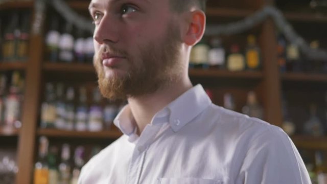 Young handsome man waiting for someone with glass of wine in restorount, slowmo
