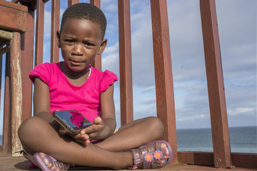 Little girl on deck with mobile phone