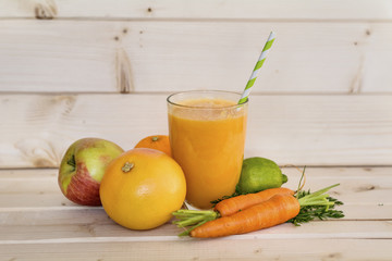 A glass cup of orange, carrots, apple and kiwi smoothie . Healthy life concept