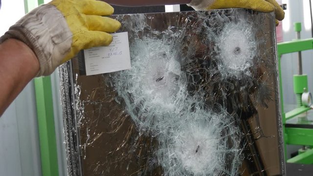 Several Round Cracks and a Lot of Fractures From Bullets Shot to Test the Multilayer Bulletproof Glass in Some Laboratoryin Kiev