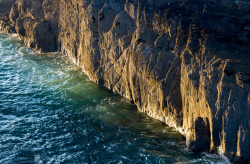 Steep cliff illuminated by the setting sun. North Devon coast. Ilfracombe. England.