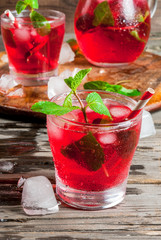 Summer iced drink - tea or juice with ice and mint. On rustic wooden table, copy space