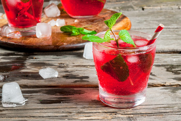 Summer iced drink - tea or juice with ice and mint. On rustic wooden table, copy space