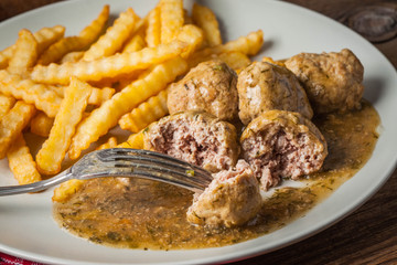 Meatballs with french fries in dill sauce.