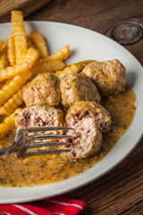 Meatballs with french fries in dill sauce.