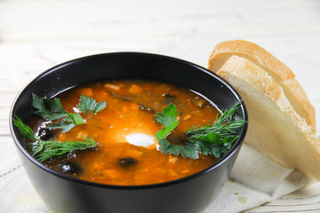 delicious saltwort soup in a black bowl and bread	