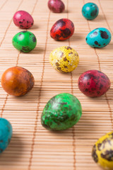 Color quail eggs on the straw background