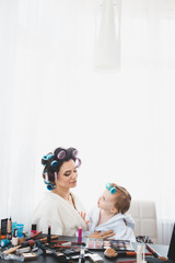 Beautiful woman and her daughter doing make up