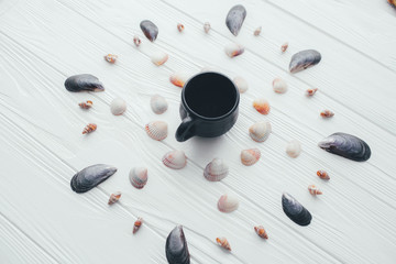 cup of coffee and sea shells on a white background 