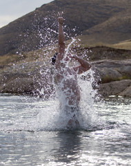 a man jumps out of the water