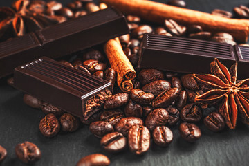 Coffee cup, spices and chocolate on wooden table texture with co