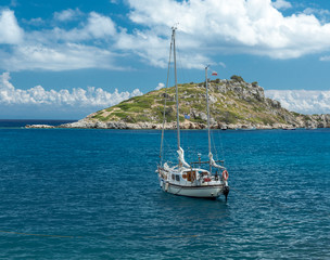 Yacht near island in the Mediterranean sea