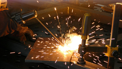 Steel worker welding, lots of sparks in metal industry