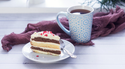 A cup of tea and a piece of tasty creamy cake