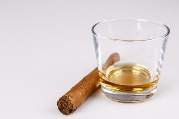 expensive drink of whisky or rum with cigar on white
