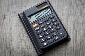 black calculator on wooden floor