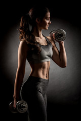 Atractive fit woman works out with dumbbells as a fitness concep