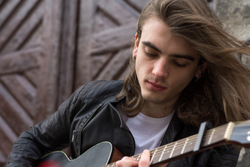 Guitar player playing song outdoor
