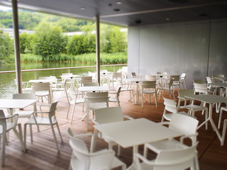 Restaurant im Grünen mit Tischen und Sesseln und schöner Aussicht