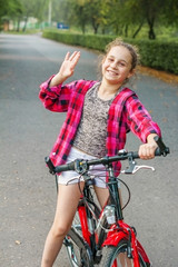 Fototapeta na wymiar Girl child 10 years old on a Bicycle in the Park.