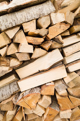 Firewood background - chopped firewood on a stack. Dry chopped firewood logs in a pile. Nature abstract background with stack of firewood.