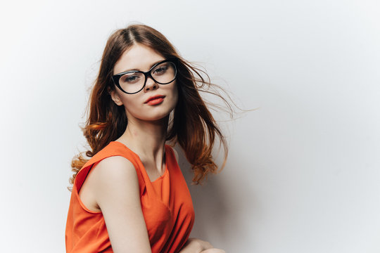 beautiful woman in an orange dress and wearing fashion glasses