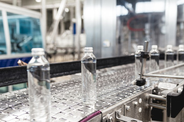 Water factory - Water bottling line for processing and bottling pure spring water into small glass bottles. Selective focus.