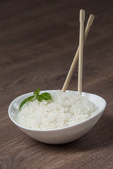 White rice in ceramic bow with wooden sticks