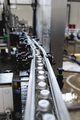 Water factory - Water bottling line for processing and bottling pure spring water into small glass bottles. Selective focus.