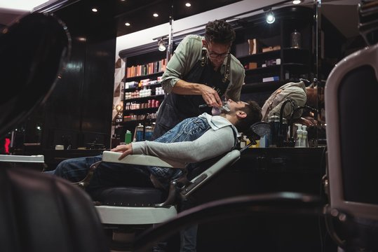 Man getting his beard shaved with razor
