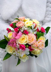 Wedding bouquet of pink, white and cream flowers held by the bri