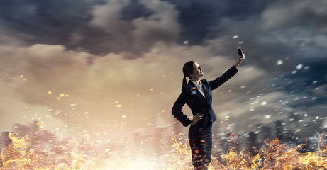 Businesswoman catching moment on her mobile . Mixed media