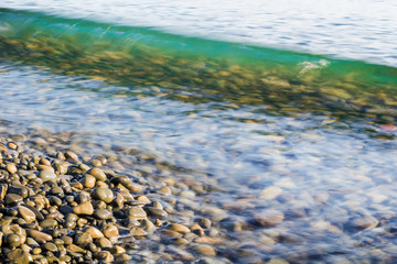 Wavein ocean and beautiful stones on beach