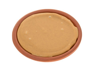 Bowl of peanut butter isolated on a white background