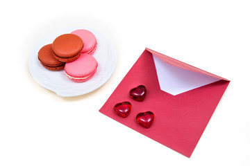 Obraz na płótnie Canvas Open red envelope and macarons on the white background.