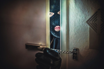Einbrecher öffnet Wohnungstüre mit Türkette
