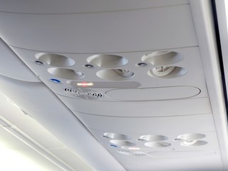 Overhead console in the modern passenger aircraft. Air conditioner button and lighting switch