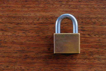 Fototapeta premium Padlock on the brown wooden table background.